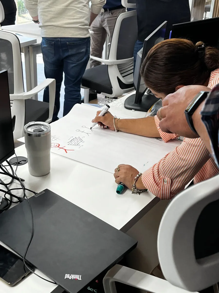 Detalle de un participante anotando ideas en una sesion de coaching